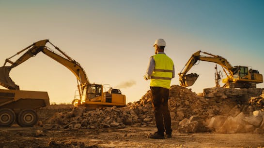 Bauarbeiter mit Bagger im Hintergrund Bauarbeiter mit Bagger im Hintergrund