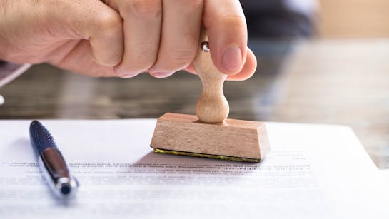 Ein Mann stempelt ein Zertifikat