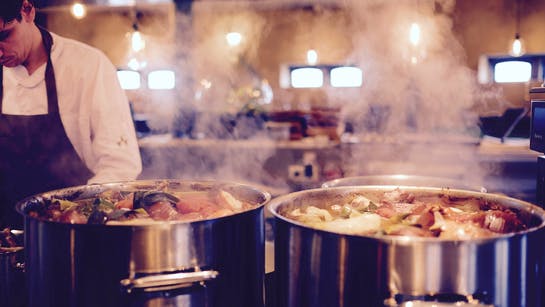 Koch mit Töpfen in der Restaurantküche Koch mit Töpfen in der Restaurantküche