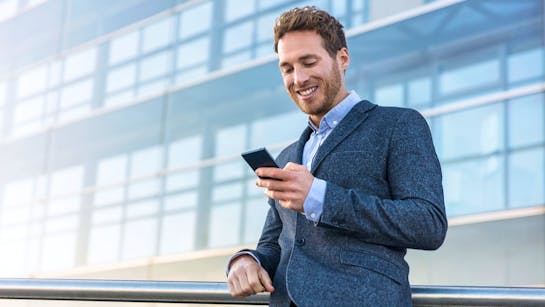 Unternehmer scrollt auf seinem Smartphone Unternehmer scrollt auf seinem Smartphone